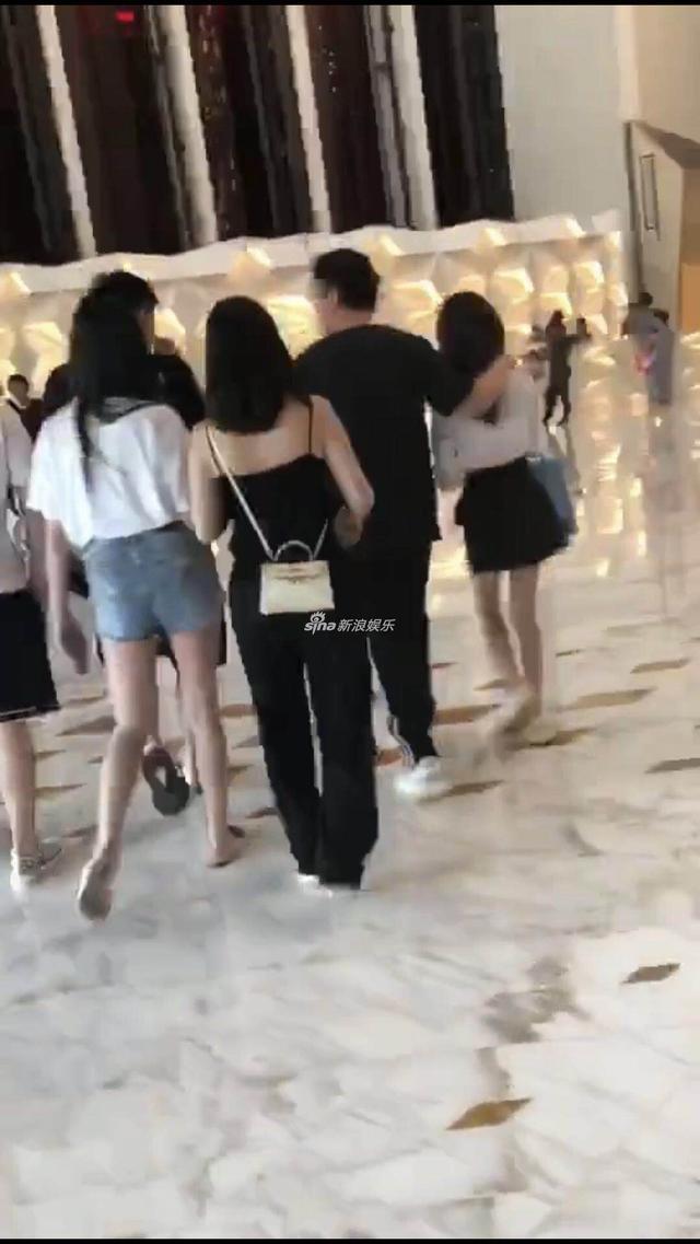 王思聪与三位美女走出酒店，搂一美女，又与两位美女嬉闹，画面惹眼