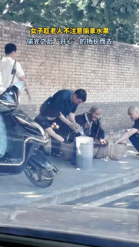 女子路边趁大爷不注意偷水果，得手后还一脸笑容……