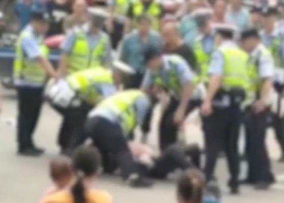 男子怀抱婴儿骑车，与交警起冲突被撂倒在地，派出所：他打交警五六拳，已带回警局