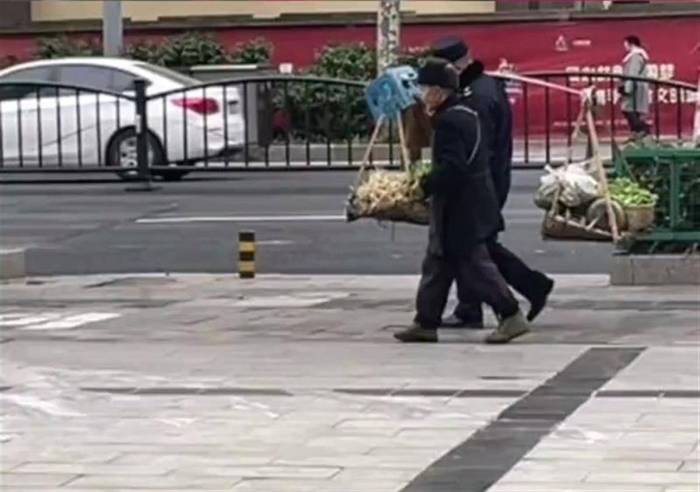 城管帮拄拐老人挑担去菜市场，社区：队员自发去做的

