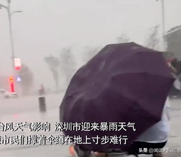 深圳大风暴雨市民撑伞蹲地寸步难行
