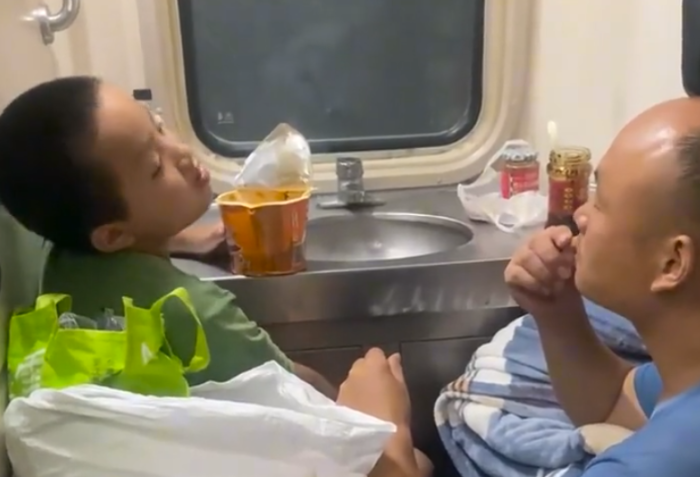 父亲在火车上蹲吃干粮把凳子给儿子