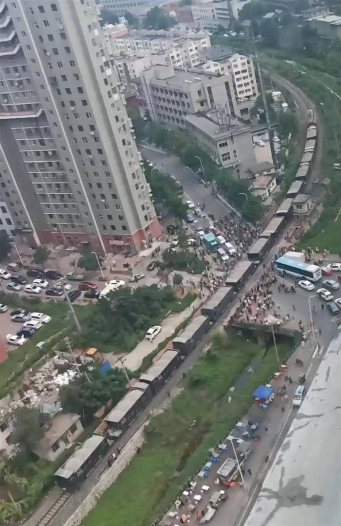 火车在铁路道口停车致双向拥堵，有市民为赶路翻火车穿行？交警部门回应

