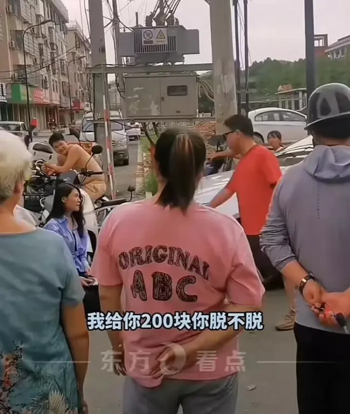女子骑车撞轿车拿200元跪地求原谅