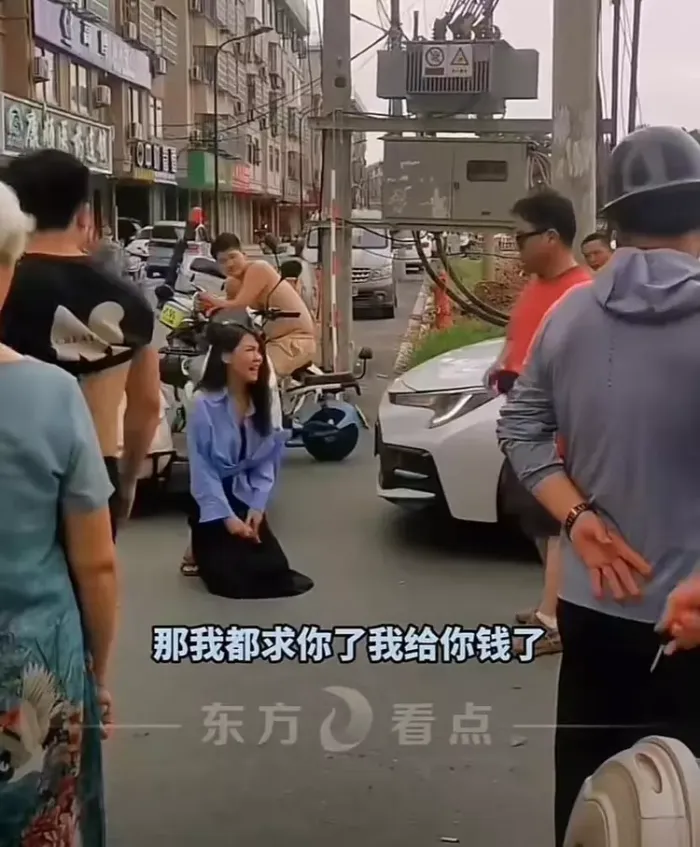 女子骑车撞轿车拿200元跪地求原谅