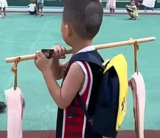 孩子扛2条五花肉送老师，走在路上格外醒目，网友：这礼物真行