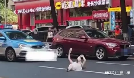 女子情绪失控在马路上打滚砸车