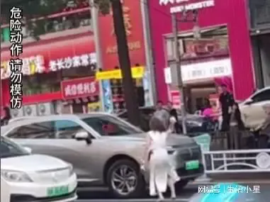 女子情绪失控在马路上打滚砸车