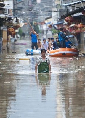 暴雨致路面积水家长划桨板接孩子放学
