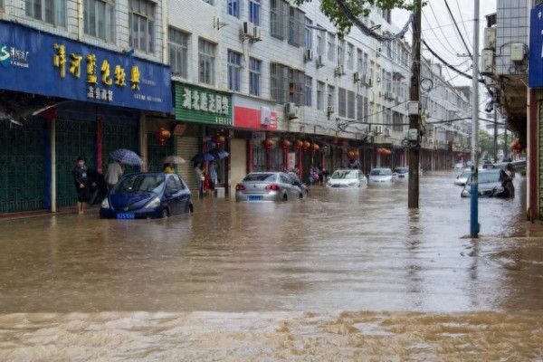 暴雨致路面积水家长划桨板接孩子放学